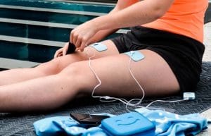 Jeune femme utilisant un appareil à électrostimulation 